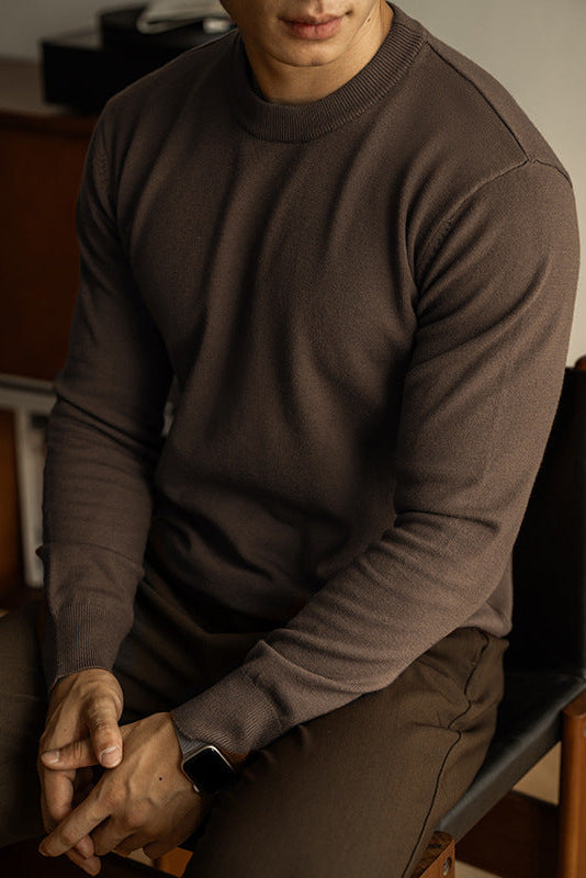 Person wearing a brown sweater sitting indoors
