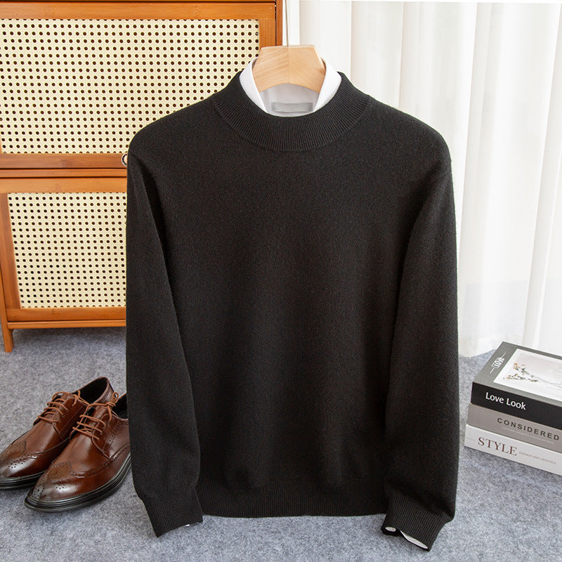 Black sweater on a hanger with brown shoes and books in the background